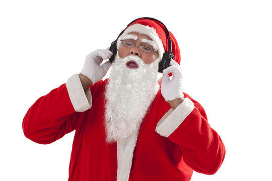 Santa Claus listening to music from headphones over white background 