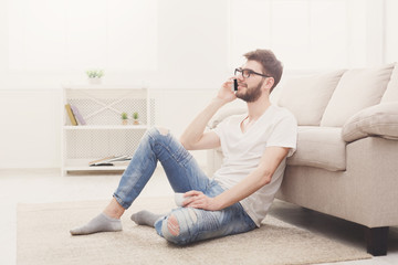 Obraz premium Man in glasses at home with mobile