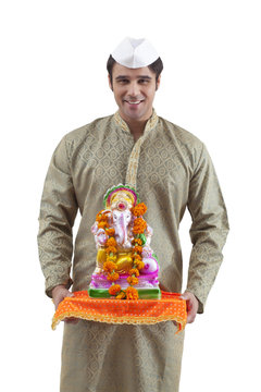 Portrait of a Maharashtrian man holding a Ganesh idol