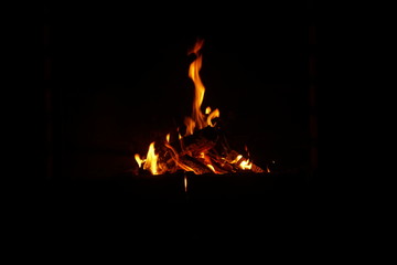 Fire burning in the fireplace on dark background