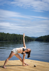 Young Woman stretching on cedar dock
