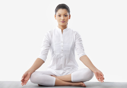 Portrait of young woman doing yoga over white background 