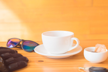 driving glove and glasses place near tea cup on the wooden table