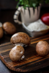 Raw mushrooms on wooden board. Three mushrooms on kitchen.