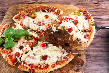 Hot pizza slice with melting cheese on a rustic wooden table. Italien food concept