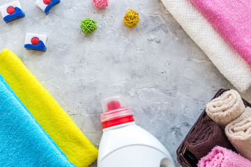 Housework. Wash clothes. Dry and liquid detergents near clean towel on grey stone background top view copyspace