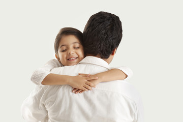 Father and daughter embracing over white background 