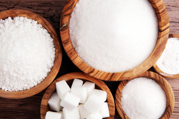Naklejka premium Sugar composition with white sugar in bowls on wooden board