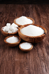 Fototapeta na wymiar Sugar composition with white sugar in bowls on wooden board