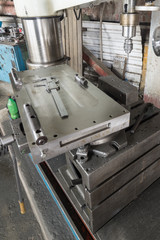 The old, working caliper lies on a polished metal surface.