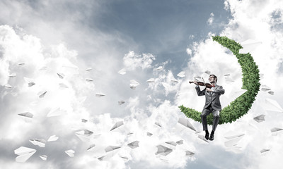 Handsome businessman play his melody and paper planes fly around