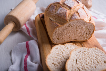 Freshly baked bread on wooden cutting board, Slice bread, wheat flour and cutting knife