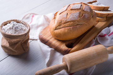 Freshly baked bread on wooden cutting board, Slice bread, wheat flour and cutting knife