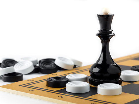 The chess queen and checkers placed on the chessboard.