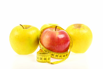 Apples of red and yellow colors wrapped with measuring tape