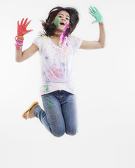 Woman with coloured palms jumping 