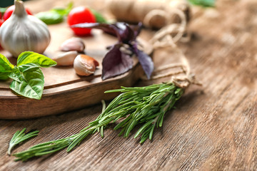 Fototapeta na wymiar Various fresh herbs with garlic on wooden table
