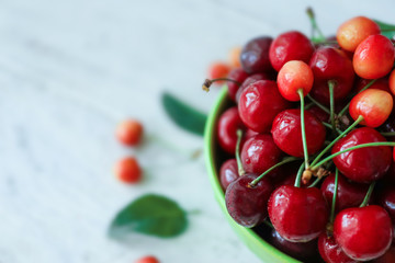 Bowl with fresh ripe cherries on blurred background