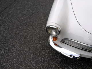 Weißer Dreizylinder Sportwagen mit traditionellem Zweitaktmotor auf grauem Asphalt beim...