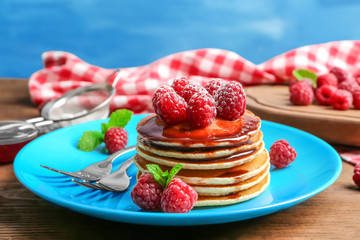 Plate with delicious pancakes on table