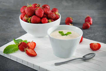 Delicious homemade yogurt and strawberry in bowls on board
