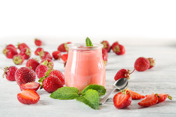 Delicious yogurt with strawberry in jar on table