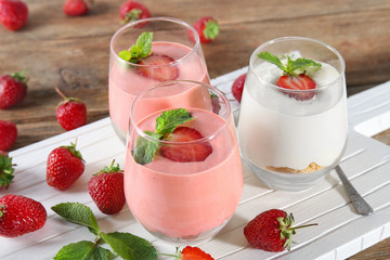 Glasses with delicious yogurt and strawberry on table