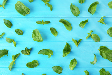 Fresh mint leaves on color wooden background © Africa Studio