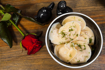 Meat dumplings - russian pelmeni, ravioli with meat on a wooden background. top view