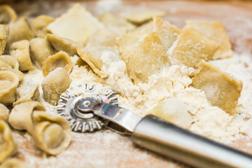 Italian ravioli on a wooden vintage wooden board, sprinkled with flour. Ravioli homemade. Top view.