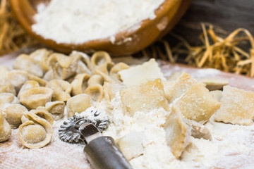 Italian ravioli on a wooden vintage wooden board, sprinkled with flour. Ravioli homemade. Top view.