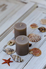 Two gray candles with seashells