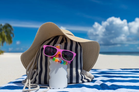 Sunscreen, Hat And Sunglasses On Tropical Beach