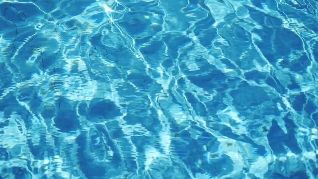 Refraction of sunlight in swimming pool water. Pool water surface, sparkles on the water in Slow Motion. 1920x1080