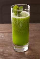 Green smoothie with spirulina on wood background