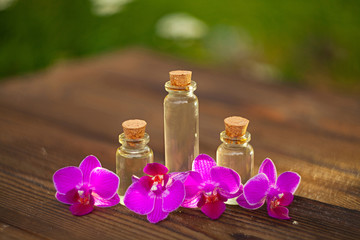 Essence of orchid flowers on table in beautiful glass jar