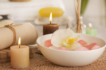 Fototapeta na wymiar Flowers in a bowl with candles and bath scrub 