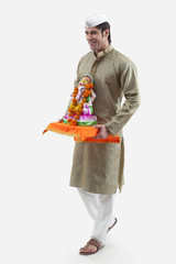 Maharashtrian man holding a Ganesh idol
