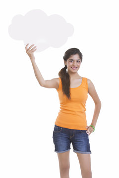 Portrait of beautiful young woman holding thought bubble over white background