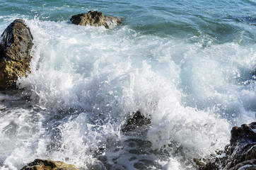 Sea wave is broken about stones.