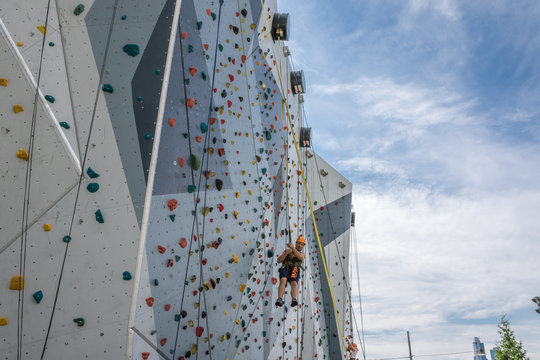 Kletterwand outdoor - Mann seilt sich ab