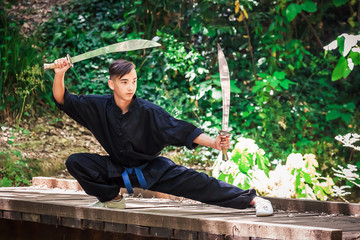 Young man practicing martial arts with a sword
