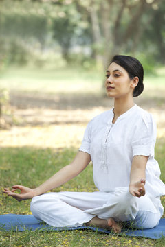 Young woman sitting in lotus position 