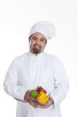 Portrait of chef with bowl of capsicum