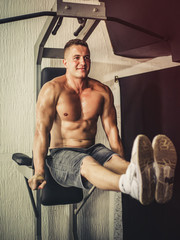 Attractive young muscular man working out his abs