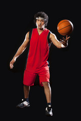 Naklejka premium Basketball player balancing ball on one finger 