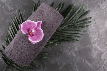 Gray towel and orchid on black marble
