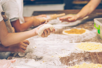 Obraz na płótnie Canvas Young children make dough. Hands close up