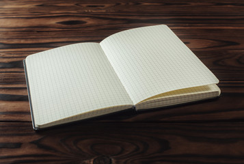 Fototapeta premium Empty notebook paper on wooden background