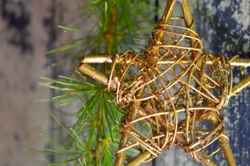 Wooden glitter star and larch branch on the old white and blue patina wooden board as a background. Christmas, New Year card. Place for text.